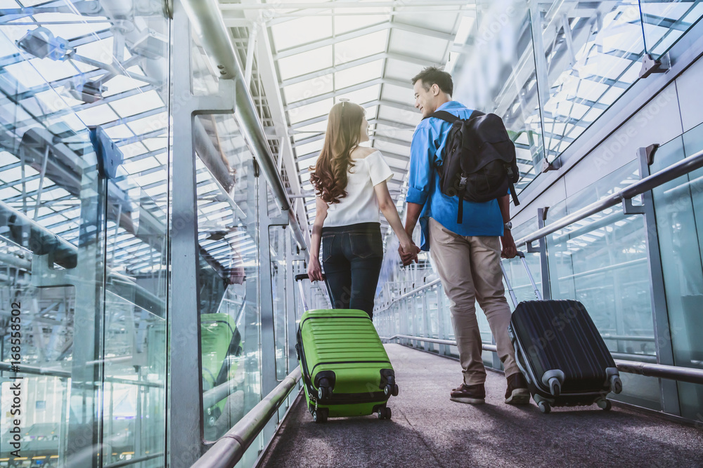 Asian couple traveler with suitcases at the airport. Lover travel and transportation with technology concept.