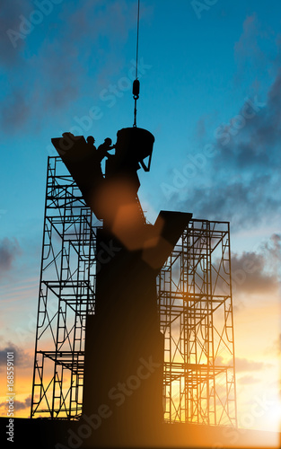 Silhouette construction industry team safely to work load concrete building according to set goal over blurred background sunset pastel for industry background.