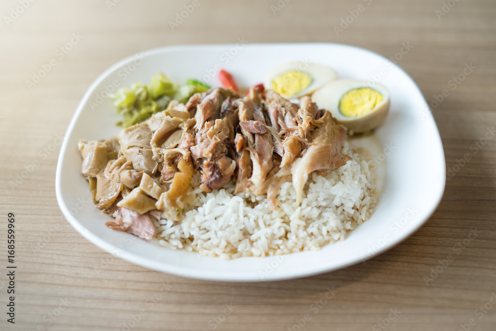 Stewed pork leg with rice on wooden table, Street food in Thailand