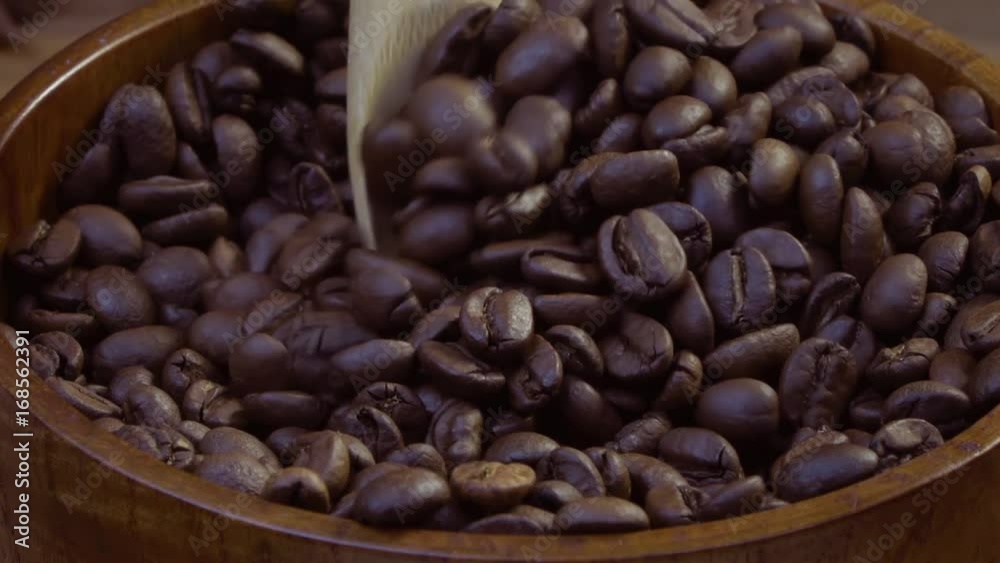 Coffee beans are mixed with a wooden spoon and are collected in a wooden spoon. Coffee beans are mixed with a wooden spoon and are collected in a wooden spoon.