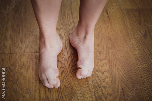 Women's feet on wooden floor.