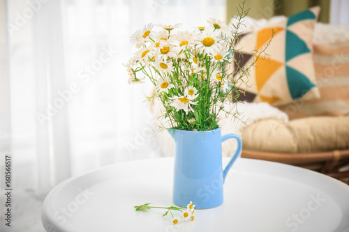 Fototapeta Naklejka Na Ścianę i Meble -  Beautiful bouquet of chamomile flowers in jug on table