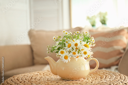 Fototapeta Naklejka Na Ścianę i Meble -  Beautiful chamomiles in small teapot on table