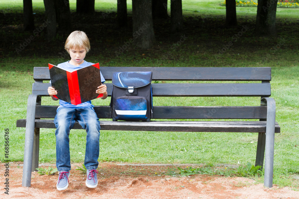 Fototapeta premium Kid doing homework outdoors after school