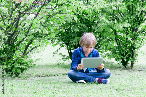 Smart boy using a tablet outdoors © vejaa