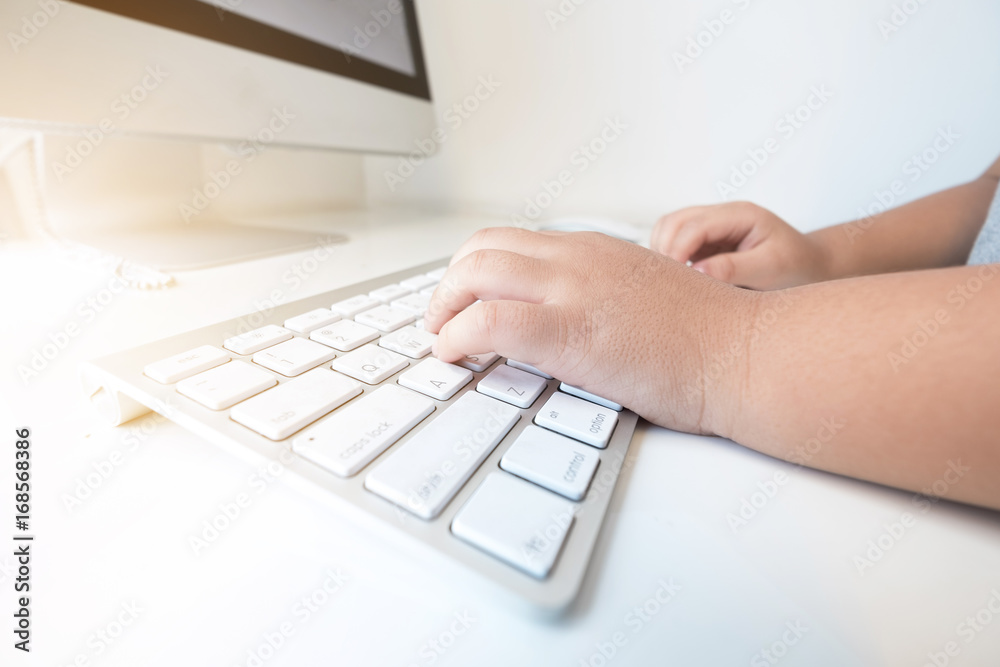 boy hands are typing on computer keyboard. Side view boy hands are typing on computer keyboard. Side view
