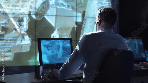 Photography Movement shot back view of man working on space mission in control center
