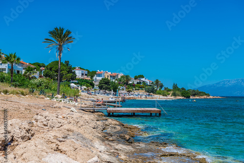 Fototapeta Naklejka Na Ścianę i Meble -  Cesme, Turkey - July 07, 2017 : People swimming and sunbathing  at Sifne Beach