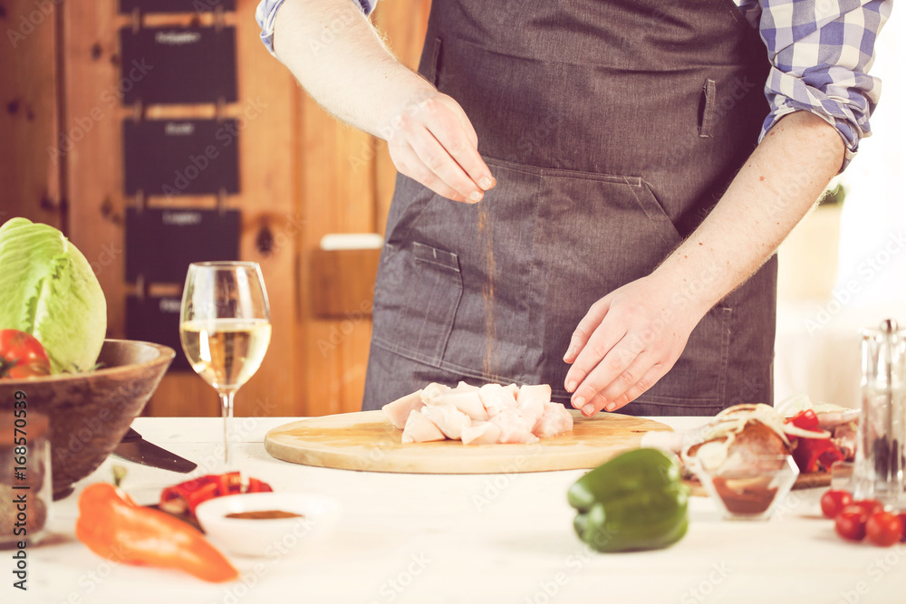 male preparing chicken for cooking