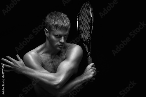 Ready to hit / A portrait of a tennis player with a racket. © Fisher Photostudio
