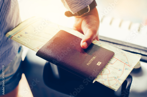 Tourists handle passports and suitcases to prepare for the trip.