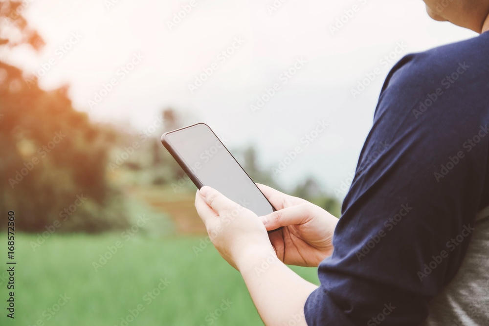people holding smartphone with nature background.