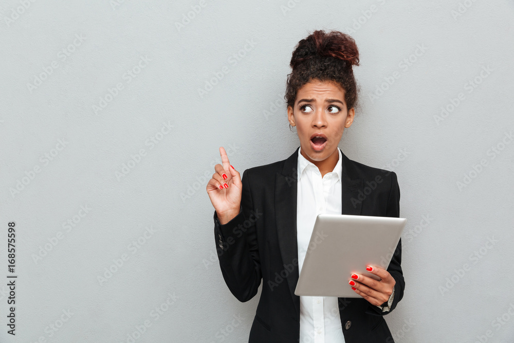 Young african shocked business woman over grey wall Young african shocked business woman over grey wall