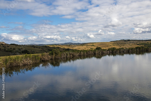 Dam Reflecting Blue Cloudy Winter Sky in Country Landscape