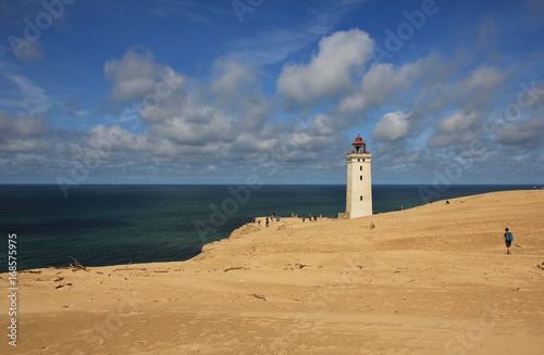 Old lighthouse partly covered by a high sand dune. Rubjerg Knude, Denmark.