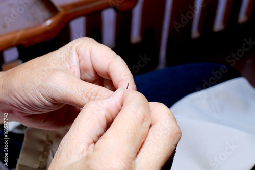 hands of seamstress at work on the wooden chair with her cloth   hand made soft toys sewing with felt and needle