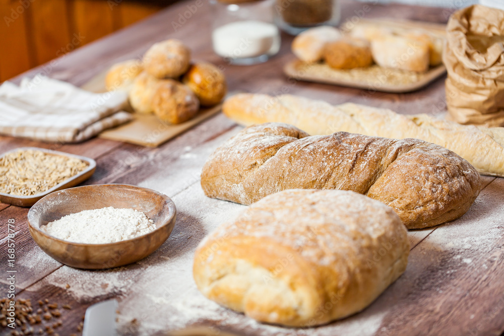 Freshly baked delicious bread on a rustic wooden table, healthy eating concept