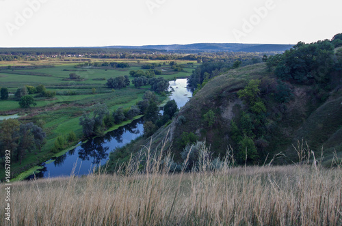 Zigzag river flows between summer valleys