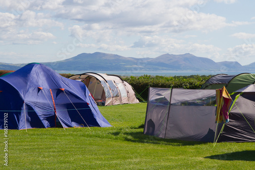 Tents on campsite overlooking Menai strait and Snowdonia mountains in Wales, UK