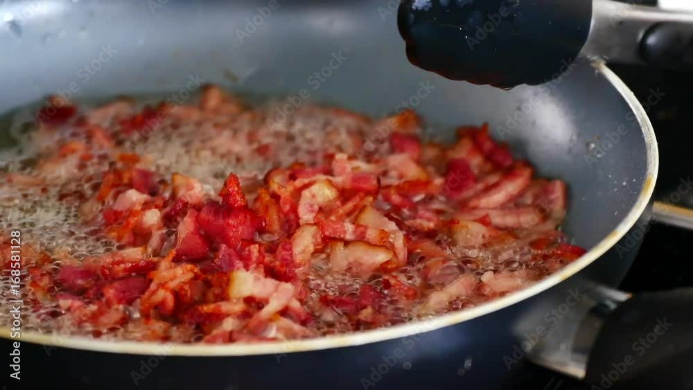 Bacon frying in the pan with the boiling oil make colorful tasty bacon. Bacon frying in the pan with the boiling oil make colorful tasty bacon.