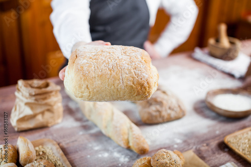 Baker man holding a beautiful fresh bread