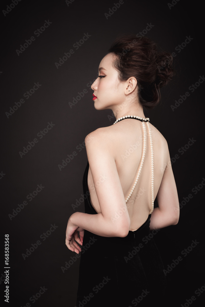 Fototapeta premium Beautiful woman portrait on black background. Young lady posing with gorgeous make up and hairstyle.