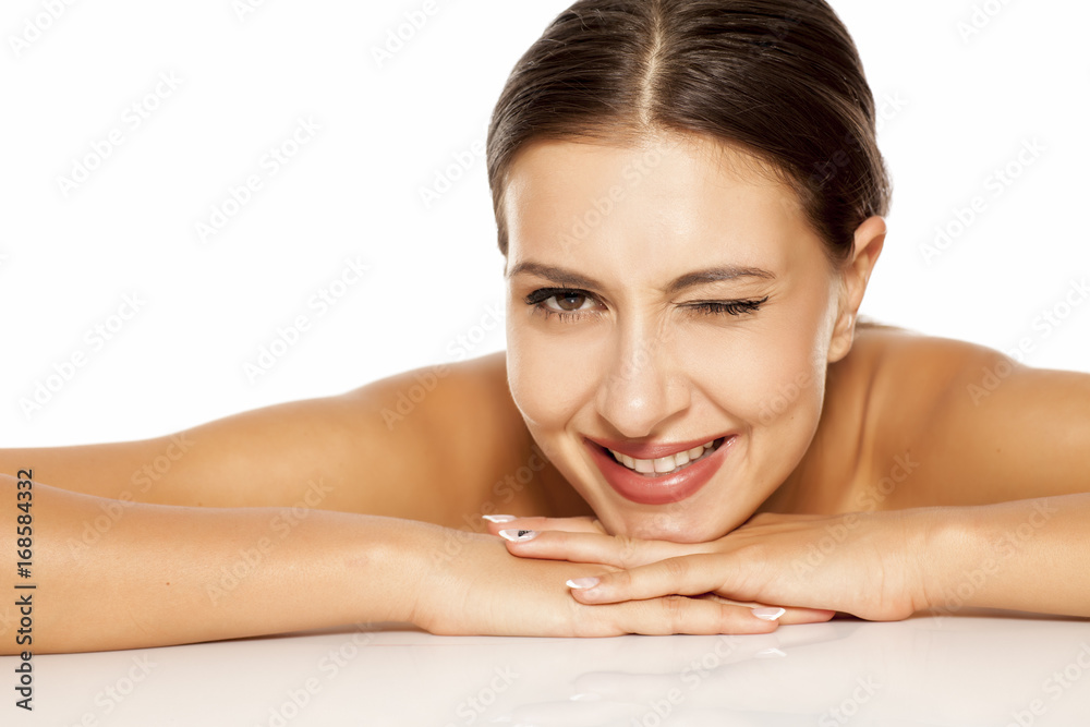 Portrait of a pretty young woman lying on a white background and