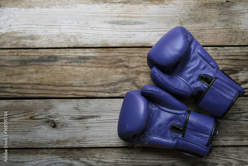 blue boxing gloves on wood table  background. top view, close-up
