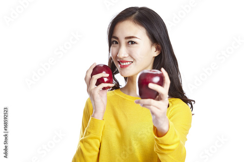 young asian woman showing two apples, isolated on white background. 