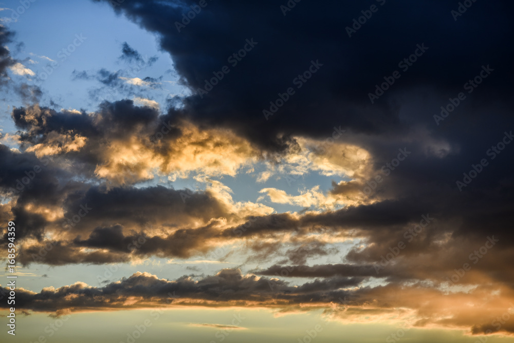 Cloudy sky during sunset in blue and yellow