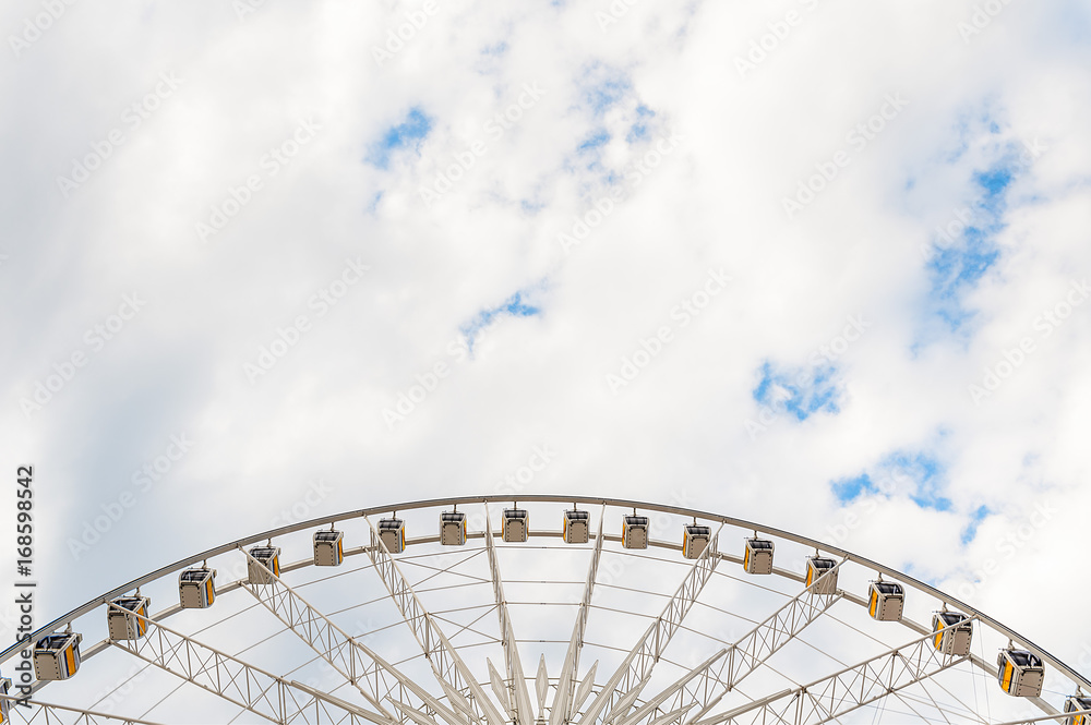 Large Ferris wheel, with blue skies and clouds background. Large Ferris wheel, with blue skies and clouds background.