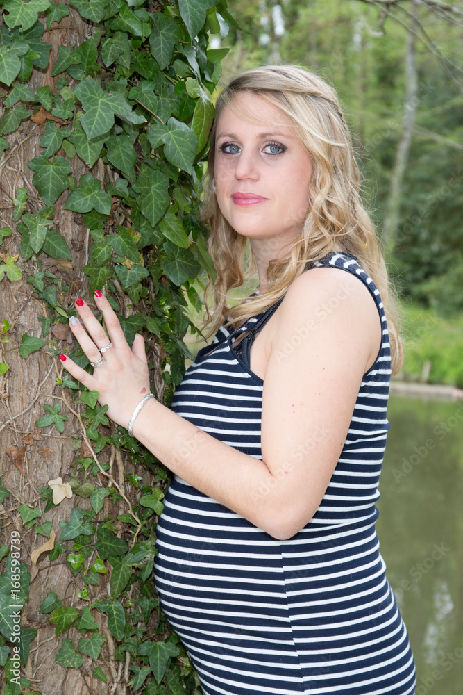 Beautiful pregnant woman relaxing outside in the park Beautiful pregnant woman relaxing outside in the park
