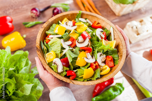 hands holding an healthy fresh vegetarian salad in a bowl