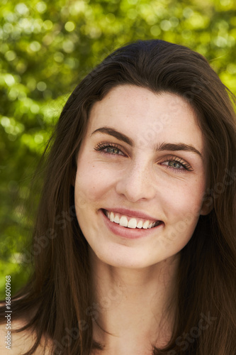 Smiling green eyed beauty with long brown hair, portrait