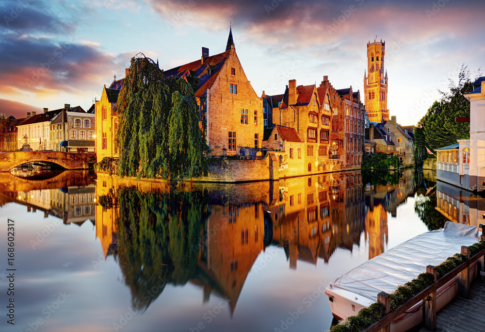 Fototapeta premium Belgia - Brugge, Rozenhoedkaai z domem Perez de Malvenda i Belfort van Brugge o zachodzie słońca