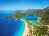 Amazing aerial view of Blue Lagoon in Oludeniz, Turkey. Summer landscape with mountains, green forest, azure water, sandy beach and blue sky in bright sunny day. Travel background. Top view. Nature
