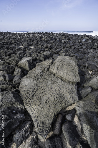 Rock beach with largs stone in front and waves, San Cristobal, Galapagos photo