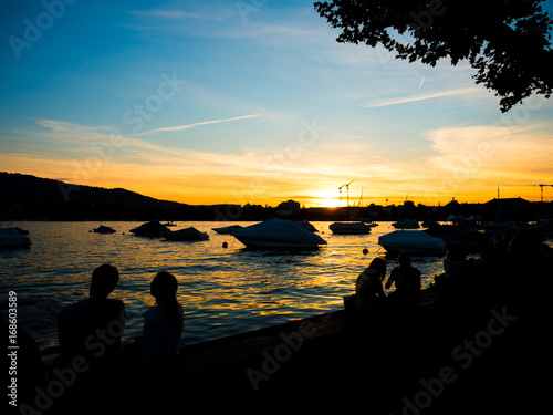 people enjoying sunset at waters edge