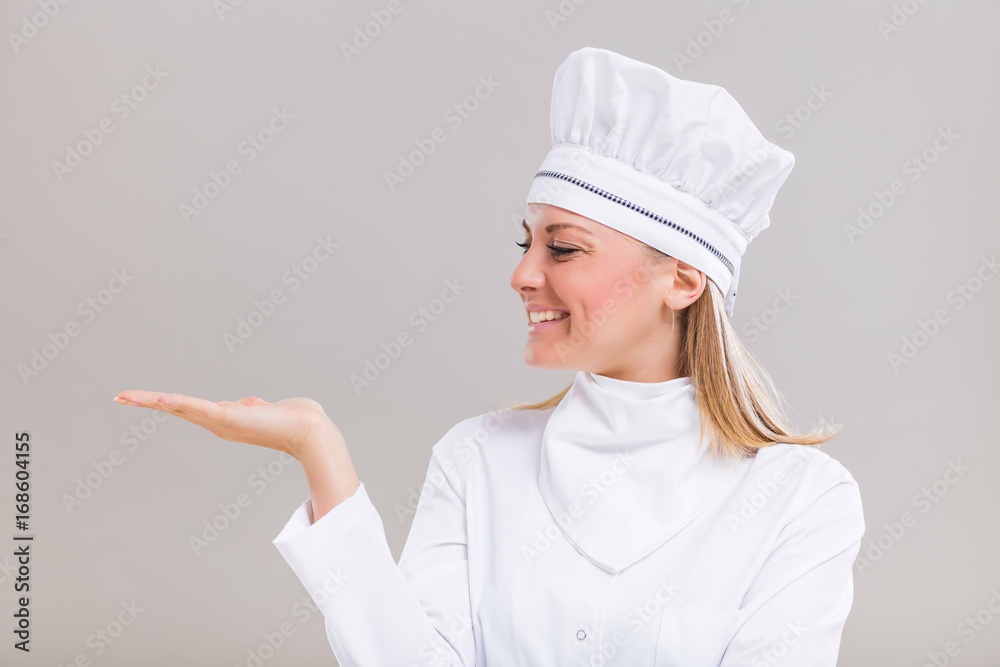 Portrait of beautiful female chef gesturing on gray background. Portrait of beautiful female chef gesturing on gray background.