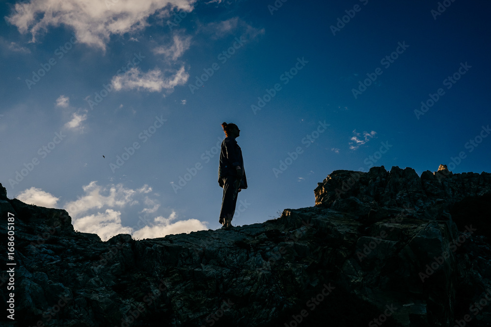 Photography of a beautiful silhouette of a natural landscape at dusk with a cloudy and colorful sky. Lifestyle portrait.