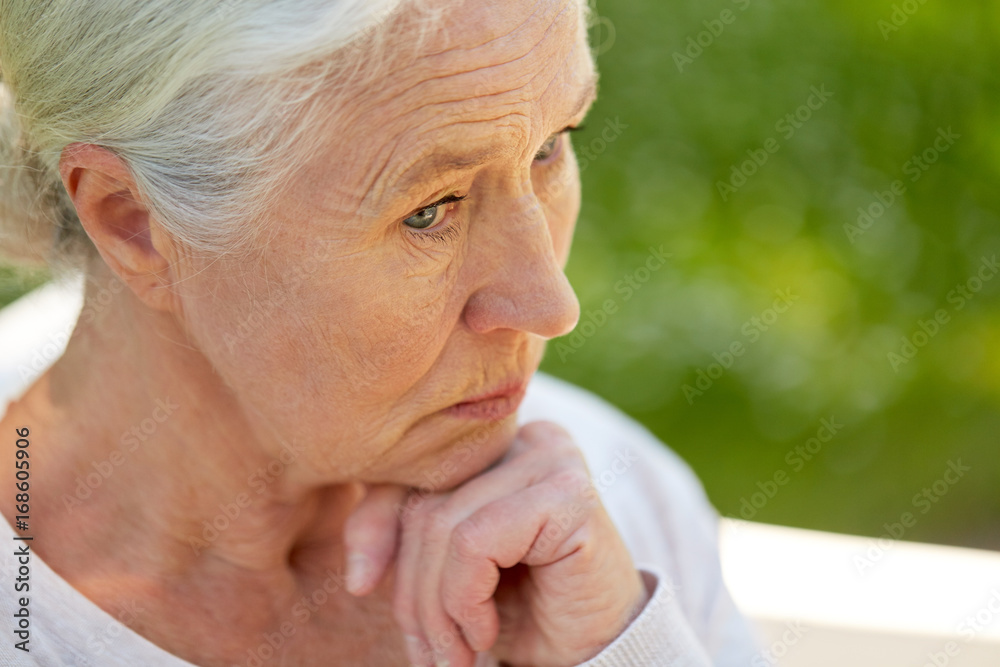 sad senior woman sitting on bench at summer park sad senior woman sitting on bench at summer park
