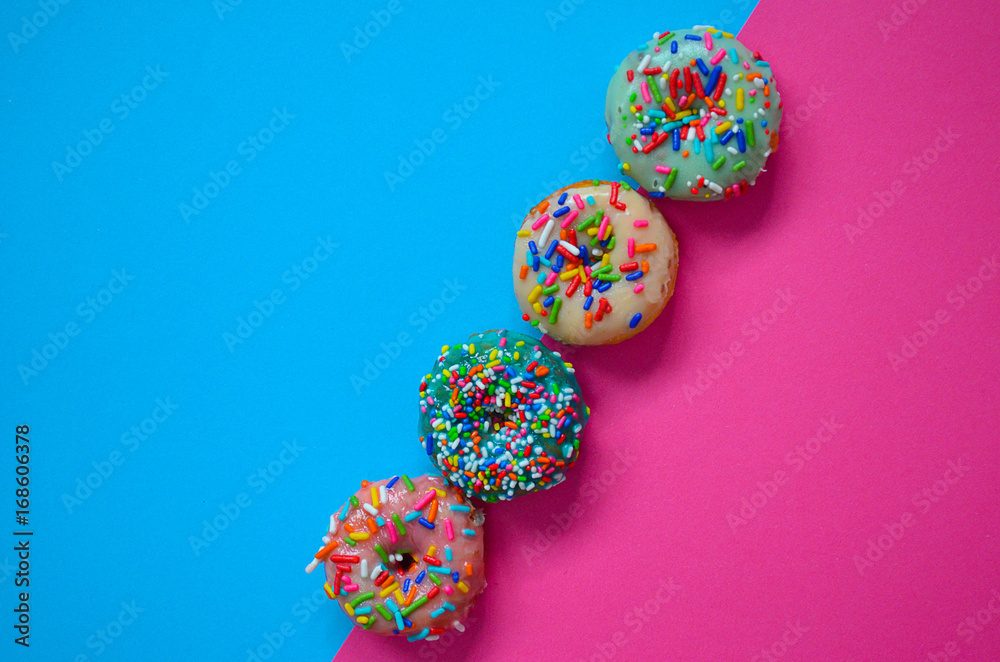 Colorful American donuts on the blue and pink background Colorful American donuts on the blue and pink background