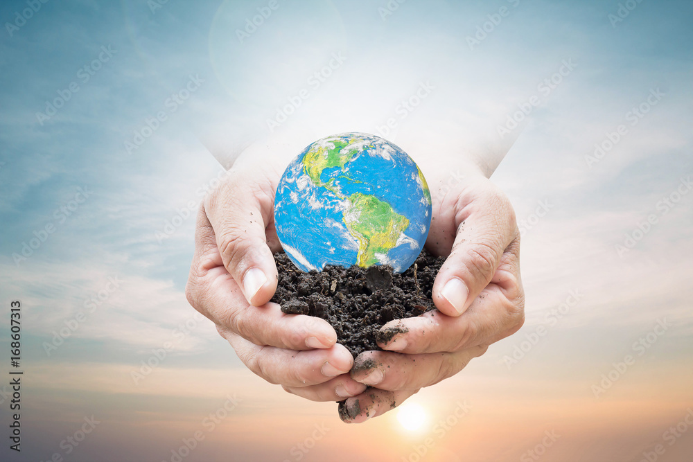 Human hands holding soil emerges from the sky in the background blurred. Create a new world. loves the world.Environment Day Ecology concept. Elements of this image furnished by NASA. Human hands holding soil emerges from the sky in the background blurred. Create a new world. loves the world.Environment Day Ecology concept. Elements of this image furnished by NASA.