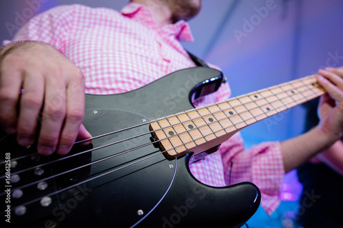 Uomo bassista che suona un basso elettrico photo