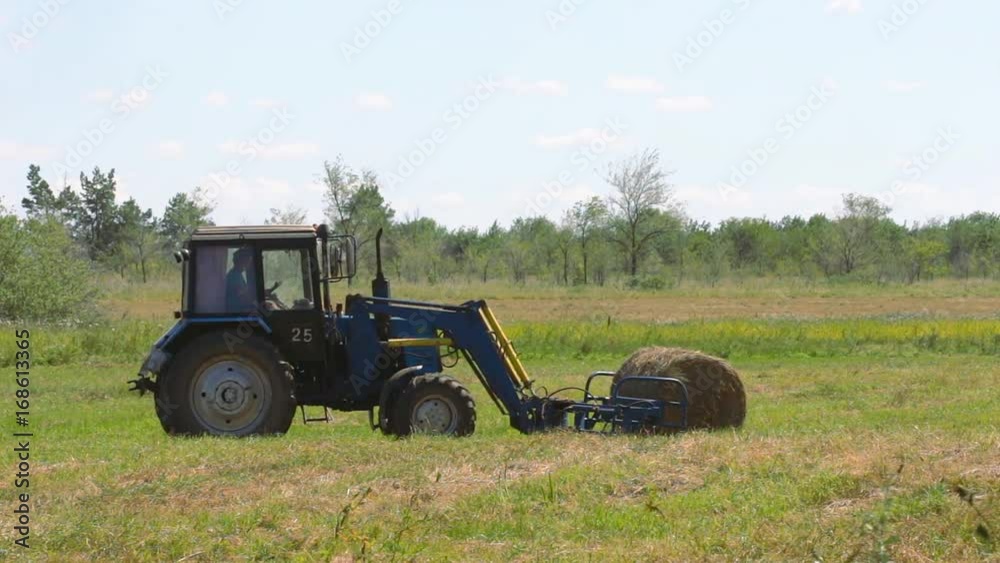 Harvesting hay. Tractor loading hay bales on a trailer Harvesting hay. Tractor loading hay bales on a trailer
