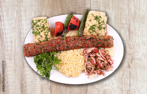 Adana kebab plate on wooden floor