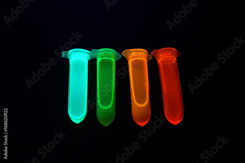 Plastic tubes with quantum dots of perovskite nanocrystals glowing in the dark due to ultraviolet radiation photo