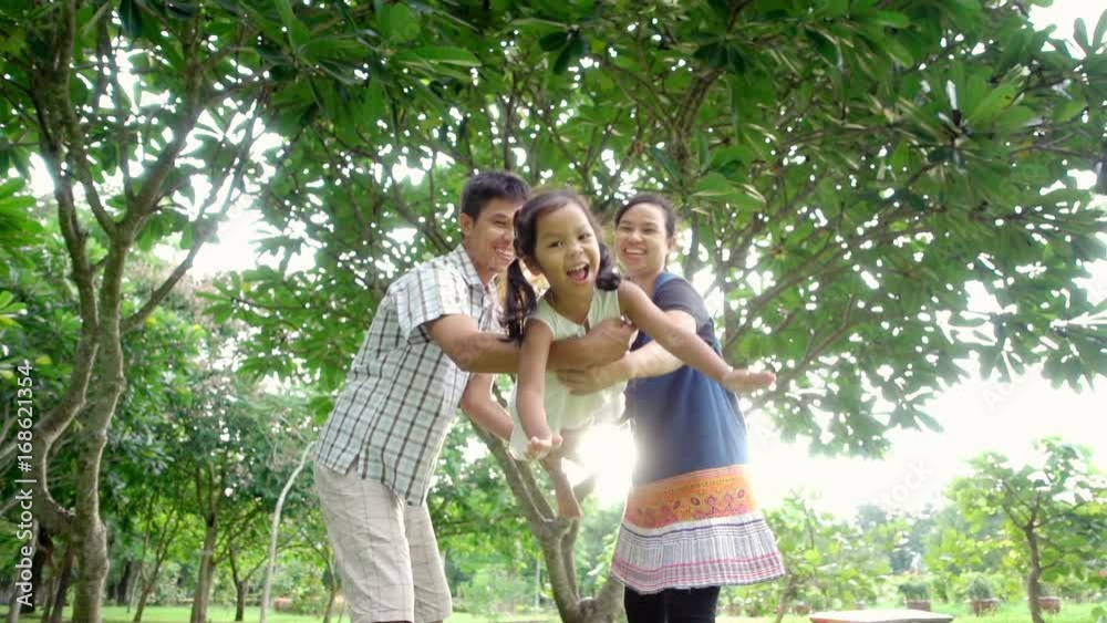 Young parent with adorable little preschool girl playing in garden with lovely. Concept of family love in free day or holidays. Slow motion shot Young parent with adorable little preschool girl playing in garden with lovely. Concept of family love in free day or holidays. Slow motion shot