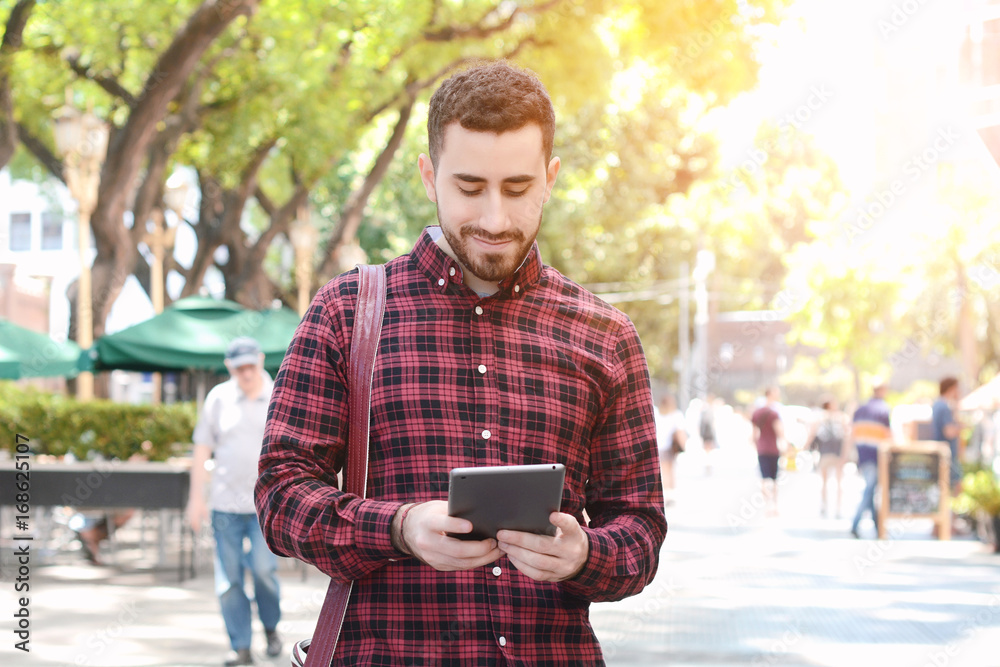Fototapeta premium Young latin man using a tablet
