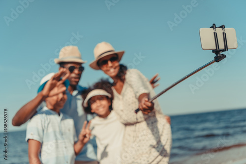 family taking selfie at seaside © LIGHTFIELD STUDIOS
